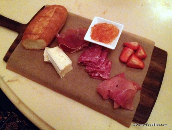 Assorted Cured Meats and Cheeses -- alpine-smoked ham, serrano ham, sopressata, and cheese served with marmalade, fresh fruit, and toasted baguette